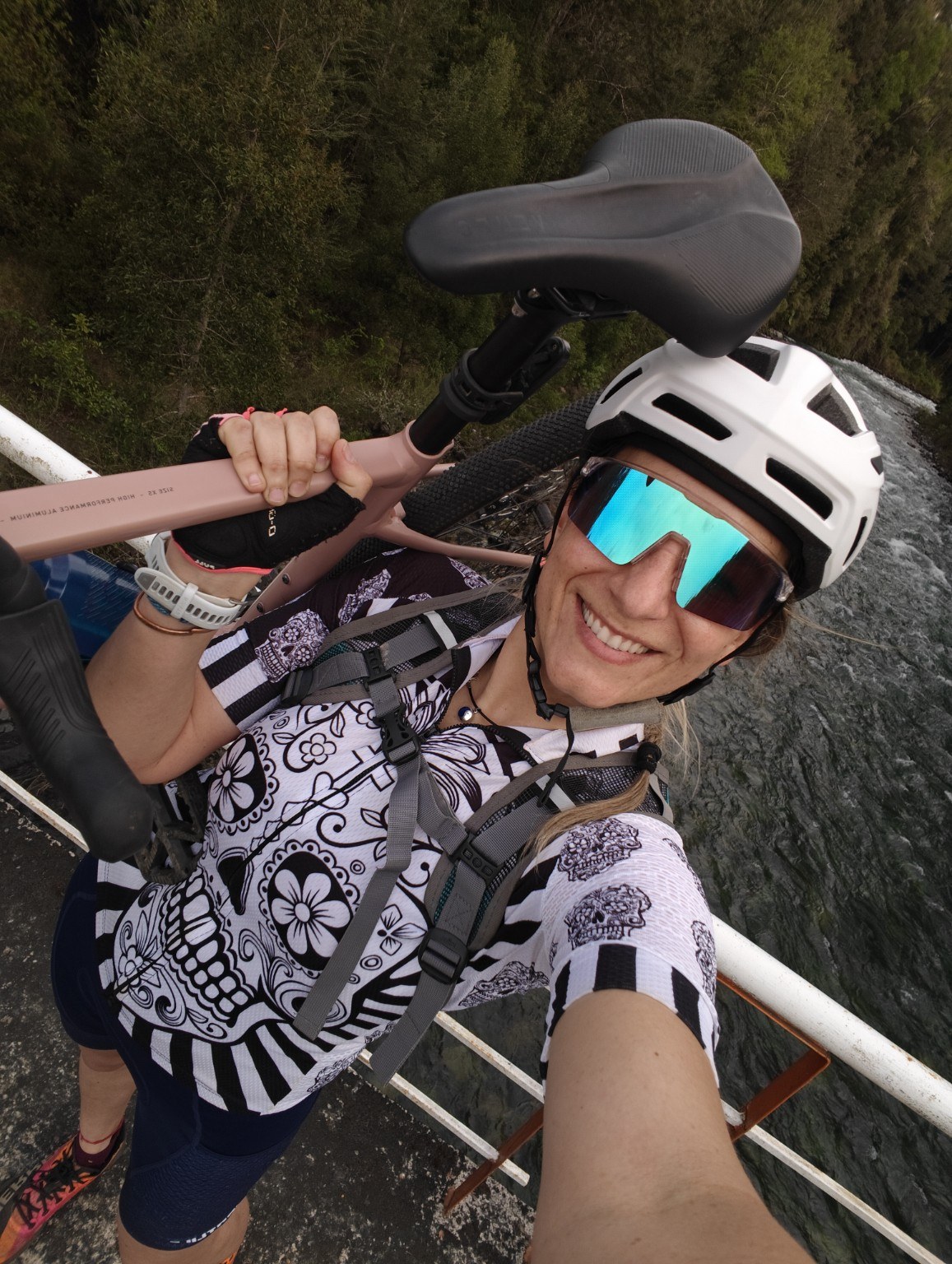 Selfie de ciclista con casco y bicicleta junto al río
